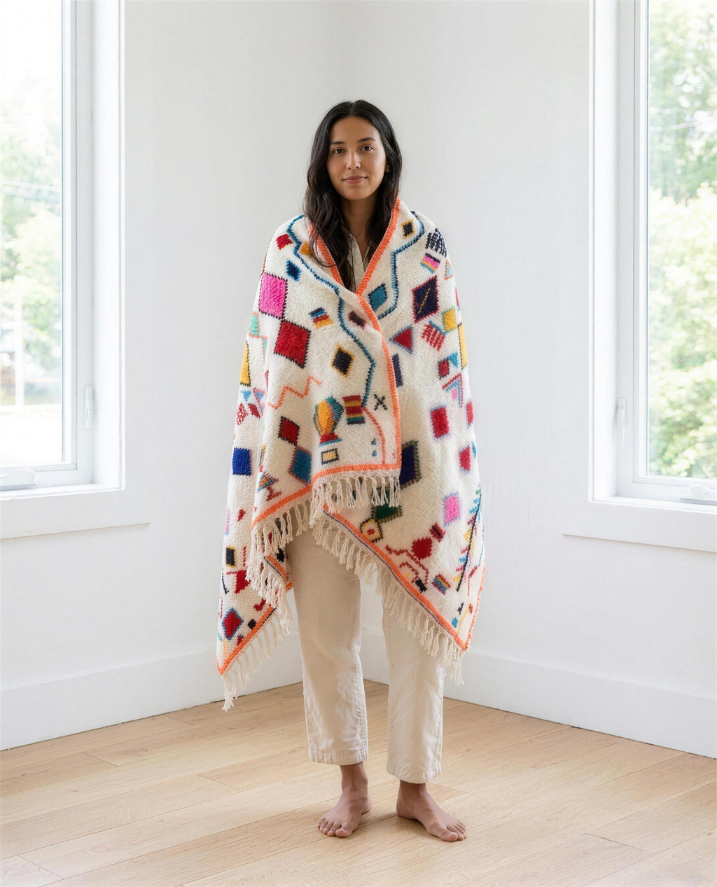 Woman wrapped in the colourful Azilal Berber throw in a bright modern interior