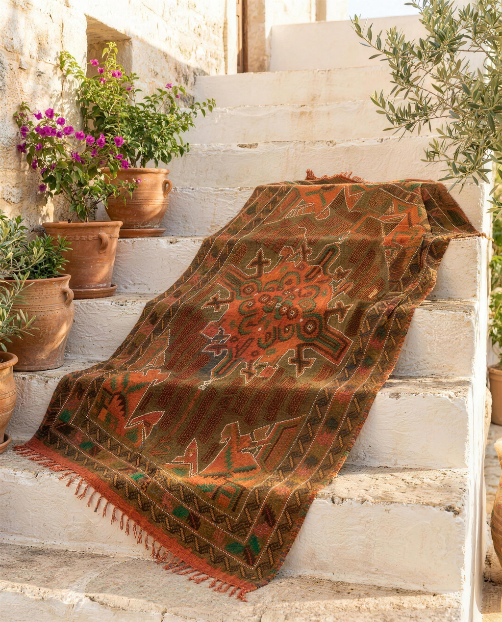 Colourful tribal Berber throw draped over whitewashed stone steps